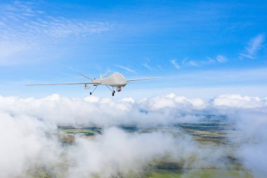 İnsansız bir araç bulutların üzerinde uçuyor. Bölgeyi kontrol ediyor ve gökyüzünü takip ediyor.