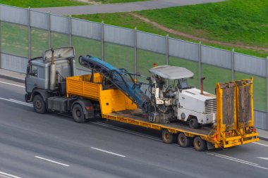Eski asfalt kaldırımları kesme ve kaldırma ekipmanları bir kamyon platformu üzerinde yol onarımı için Kentteki bir otoyolda, yan hava manzaralı
