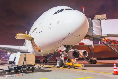 Burun ve kokpitin gece görüşü uçuş öncesi bakım servisi sırasında büyük bir uçak.