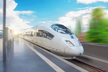 Yüksek hızlı tren, hareketin etkisiyle hızlı bir hızla yolcu istasyonunun yanından geçer.