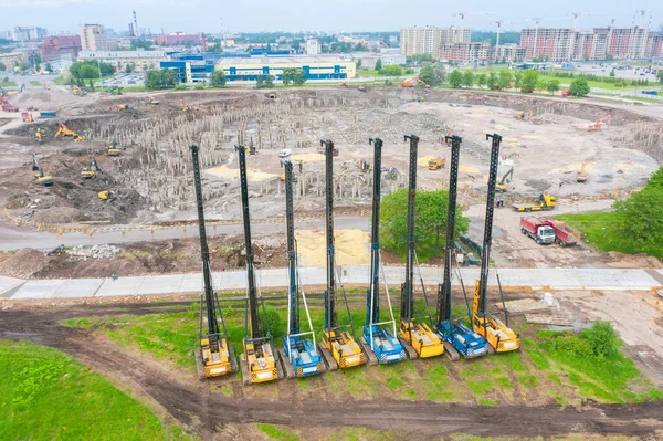 Heavy equipment for installing piles in the ground, heavy machines for driving foundation pillars are lined up. Construction aerial view from height