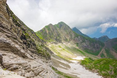 Dağlı vadi, karlı, kayalıkların ve tepelerin etrafında