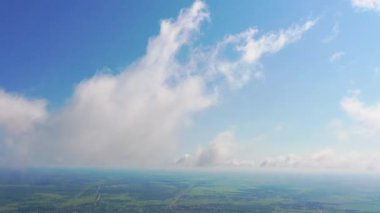 Kabarık bulut katmanlarında uçuyor. Kamera yerin üstünde dönüyor. İnanılmaz yumuşak beyaz bulutlar berrak gökyüzünde yavaşça hareket ediyor.