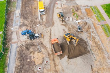 Şehir caddesi inşaatı, iletişim kurulumu kanalizasyon kapakları, oluklar, kaldırımlar. Kaldırım döşeme ve hava manzarası hazırlığı