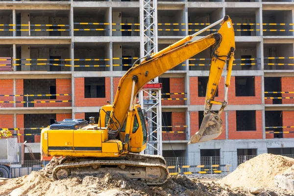 Grävmaskiner Med Upphöjda Skopor Bakgrunden Ett Flervåningshus Uppförande — Stockfoto