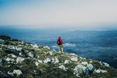 Görünüm fotoğraf Dağları'nda açık havada kırmızı ceketli genç adam geri 