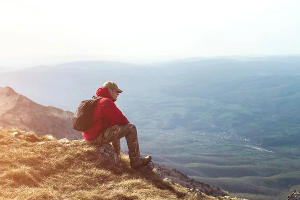 Фото Молодого Человека Красной Куртке Сидящего Каменном Открытом Воздухе Горах — стоковое фото