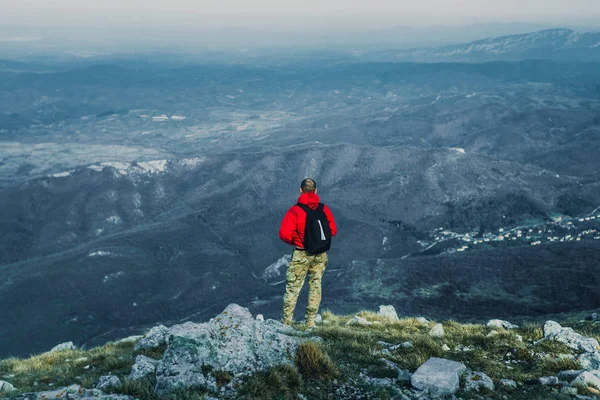 Görünüm fotoğraf Dağları'nda açık havada kırmızı ceketli genç adam geri 