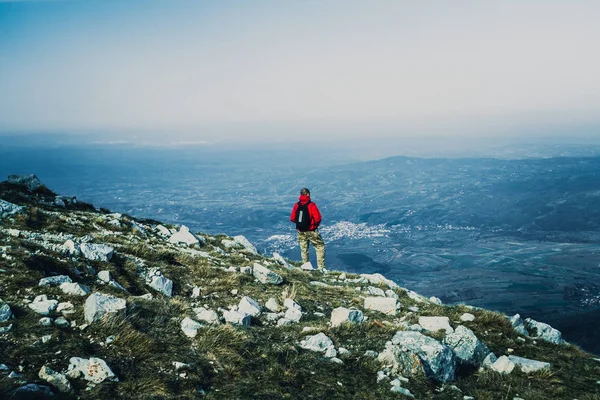 Görünüm fotoğraf Dağları'nda açık havada kırmızı ceketli genç adam geri 