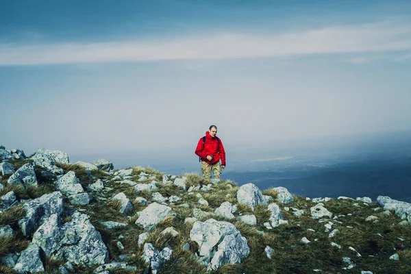 赤いジャケット野外を歩いている 山の中で若い男の写真 — ストック写真