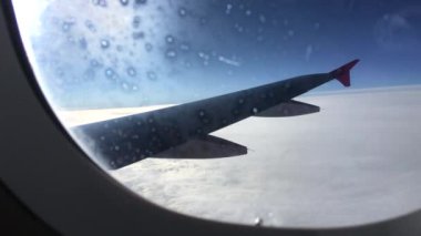 uçak kanadı ile beyaz bulutlar mavi gökyüzünde uçak penceresinden