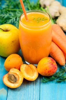 Bardak kayısı, elma, havuç ve zencefil suyu renkli turkuaz mavi ahşap Komiteler boyalı. Üstten görünüm