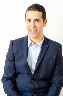 Gömlek ve beyaz arka plan karşı dururken kamera bakarak takım elbise yakışıklı genç adam portresi