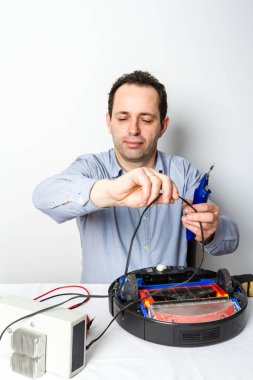 Portre profesyonel tamirci robot elektrik süpürgesi üzerinde pil değiştirme. Robot temizleyici tamir