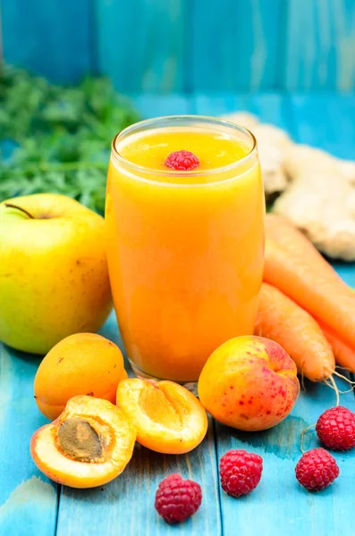 Bardak kayısı, elma, havuç, rospberry ve zencefil suyu üzerinde renkli turkuaz mavi boyalı ahşap panoları