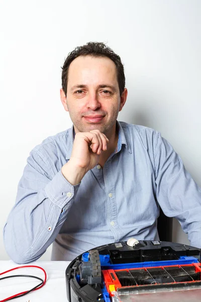 Portre profesyonel tamirci robot elektrik süpürgesi üzerinde pil değiştirme. Robot temizleyici tamir