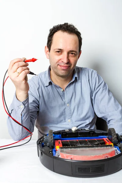 Man changing batteries on robotic vacuum cleaner. Repairing robot cleaner