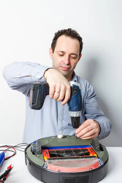 专业修理工在机器人吸尘器上更换电池的肖像 修理机器人清洗机 — 图库照片