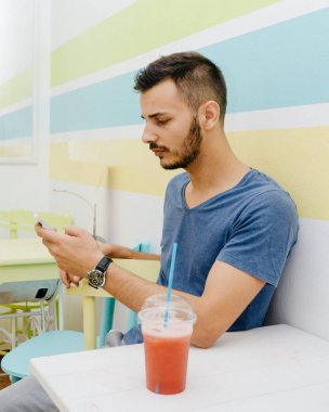 Bir an için bir meyve güler yüzlü kapmak ve onun smartphone kullanmak şık bir adam yavaşlar.