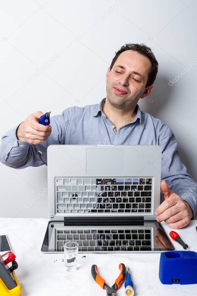 Professional repairman repairing broken laptop computer