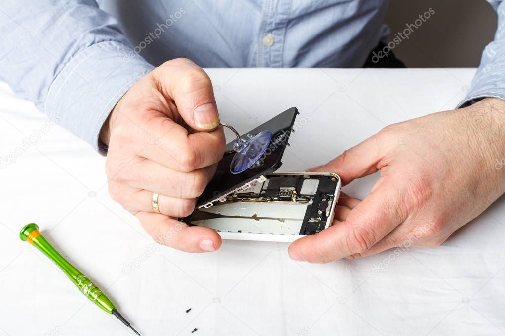 close-up of Male hands opening  broken smart phone