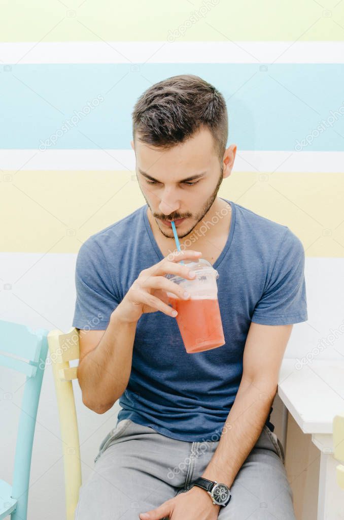 Portrait of stylish man drinking smoothie in a bar