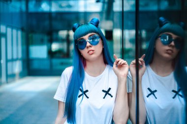 Mavi saç ve kalp gözlüklü genç kadın portresi