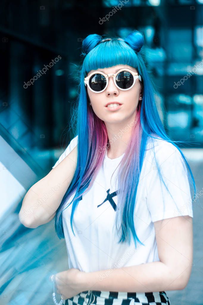 Portrait of woman with blue hair and round dark sunglasses