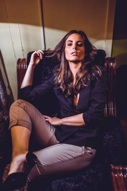 Genç ve güzel bir kadın evde koltukta, rahatlatıcı portresi 