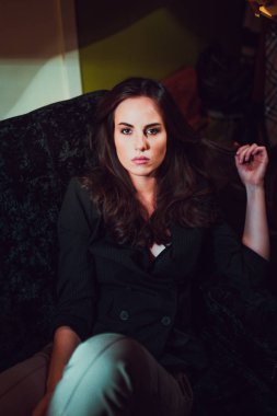 Genç ve güzel bir kadın evde koltukta, rahatlatıcı portresi 