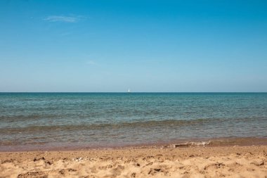 ısmarlayarak deniz su dalgalanma, kumlu plaj ve mavi gökyüzü