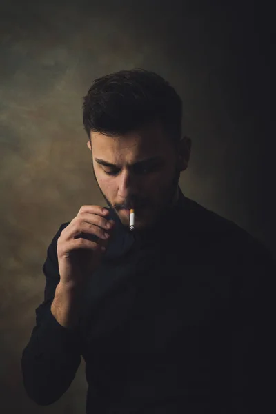 在艺术工作室抽烟的年轻人的画像 — 图库照片