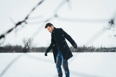 Kışın kar kucaklayan genç çekici bir adam. Portre portre