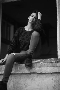 Açık havada yakınındaki eski rustik bina poz bir genç kızın en az siyah beyaz portre. Moda kavramı