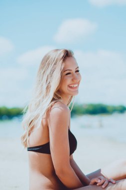 Yaz sahilde oturan moda genç kadın portresi