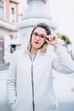 Sokak tarzı genç güzel şık kadın ceket, gözlük sonbahar moda trendi ile sokakta yürürken.