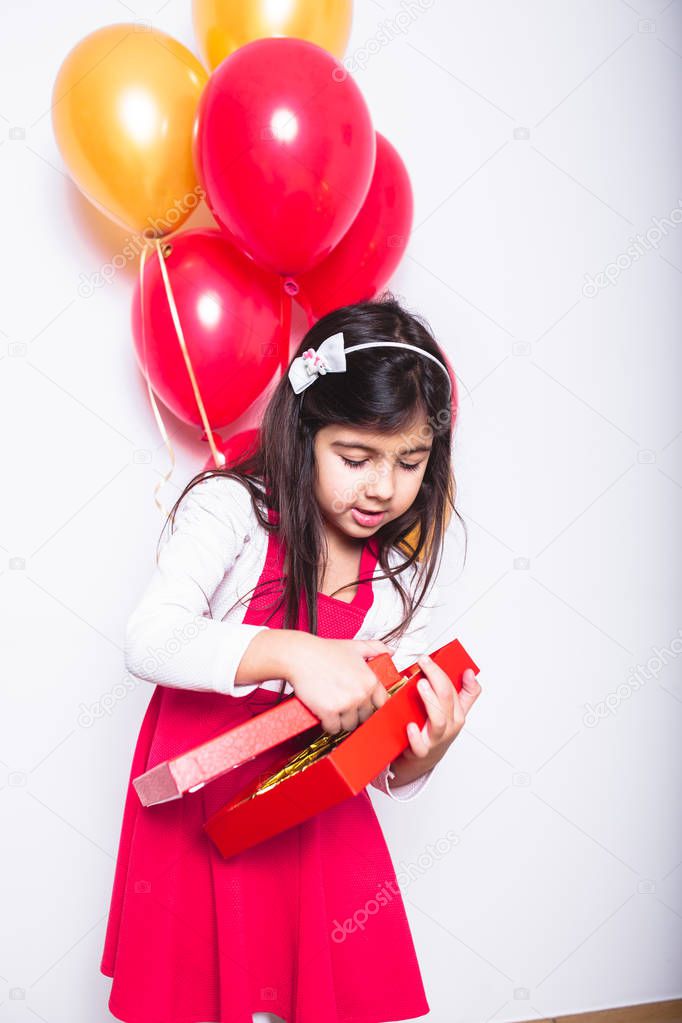 Baby Girl Holding Balloons celebrating her Birthday