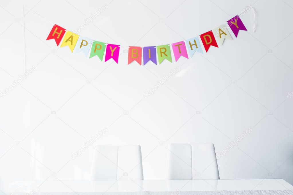 birthday colorful fabric bunting on white wall background 