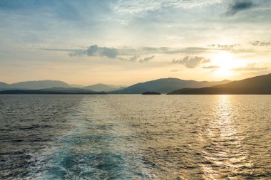 deniz ve dağlar üzerinde güzel günbatımı 