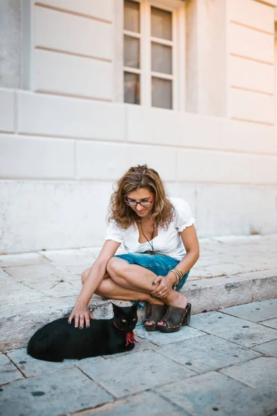 Kadın Sokakta Bir Kedi Ile Oynarken — Stok fotoğraf