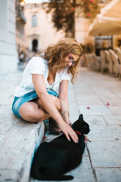 Kadın Sokakta Bir Kedi Ile Oynarken — Stok fotoğraf