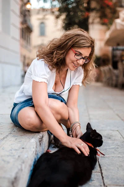 Kadın Sokakta Bir Kedi Ile Oynarken — Stok fotoğraf