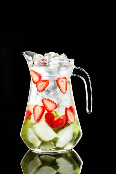 Strawberry-apple drink in a jug with ice