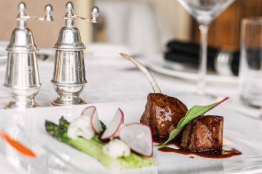 Beyaz bir tabaktabaktabaktabaktabaktabaktabaktabaktabakta sos ve kuşkonmaz ile kemik üzerinde kavrulmuş et