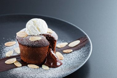 Dondurma ve çikolata ile çikolata fondan siyah bir tabak üzerine serpin.