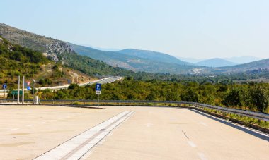 Dağlardaki yol. Kayalar ile Manzara, bulutlar ve yaz aylarında akşam güzel asfalt yol ile güneşli gökyüzü. Seyahat geçmişi. Dağlarda Karayolu.