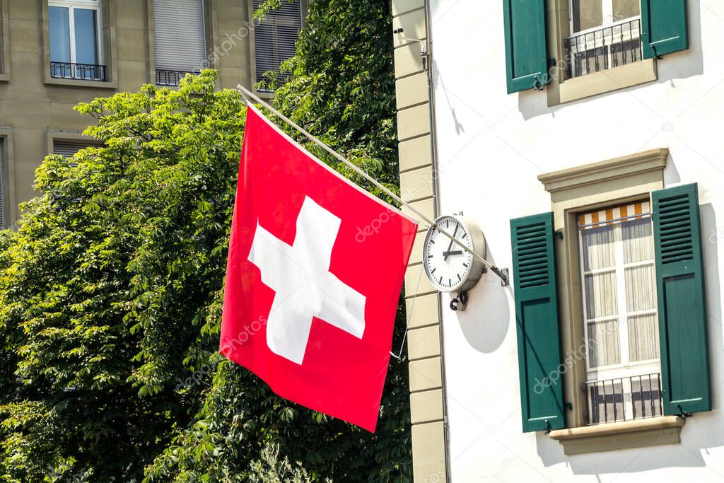 Swiss Flag hanging from a building facade in Bern, Switzerland