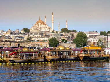 Eminonu Meydanı 'nda Eminonu Camii' nde gün batımında arkaplanda Suleymaniye Camii ile balık lezzeti sunan geleneksel fast food tekneleri