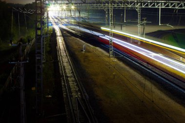 Tren gece raylar boyunca koşar. Fotoğraf Moskova 'da bir şehir caddesinde, 2018 sonbaharında, gökyüzünde, raylarda, trende çekildi. 