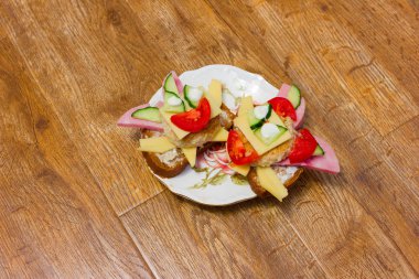 Tabaktaki kompozisyon, arka planda güzel bir sandviç şeklinde. Fotoğraf Moskova 'da, 2019 sonbaharında, tabakta, arka planda, sebzelerde, evde çekilmiş. 